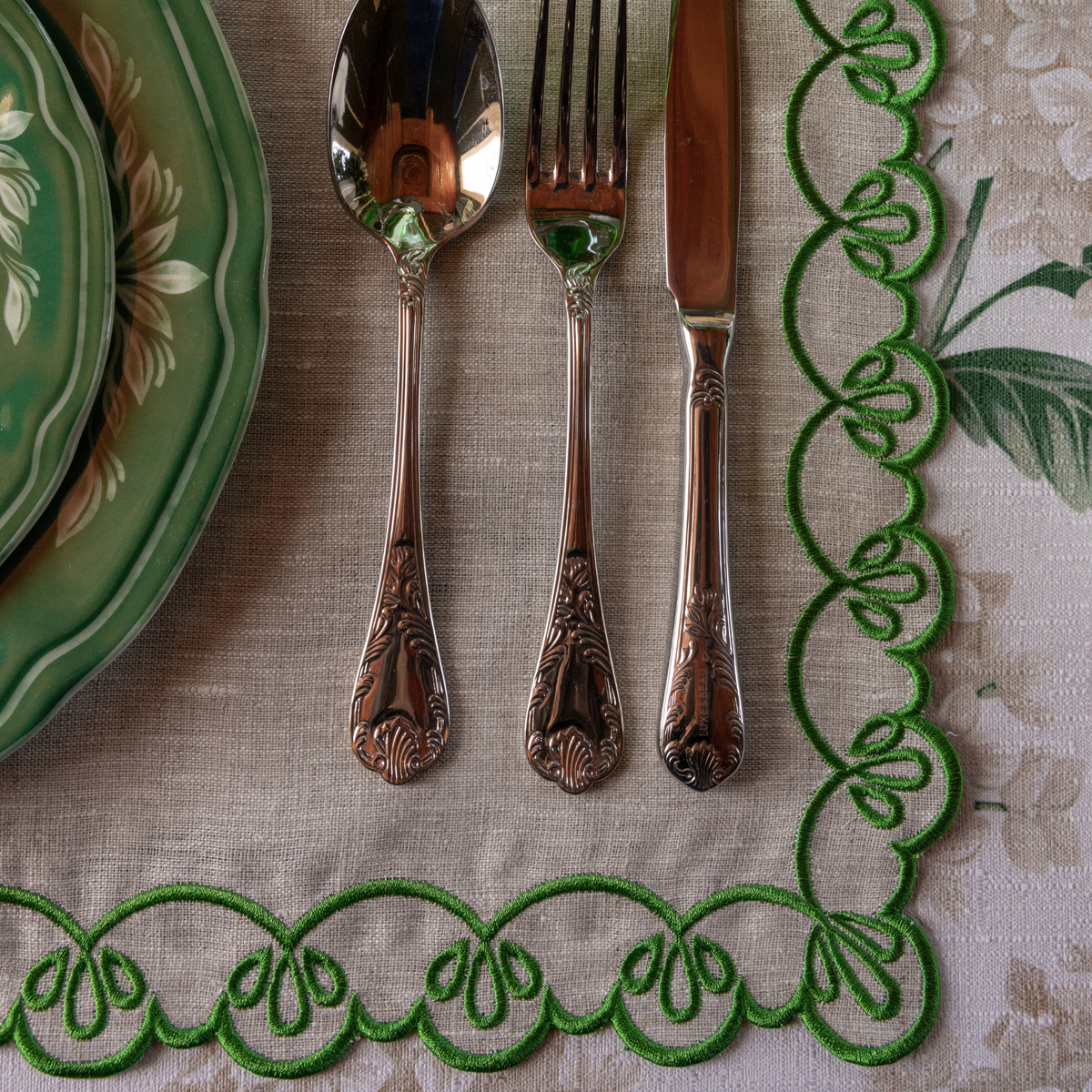 Cream Hydrangea Christmas table styled with natural linen placemats with green embroidery