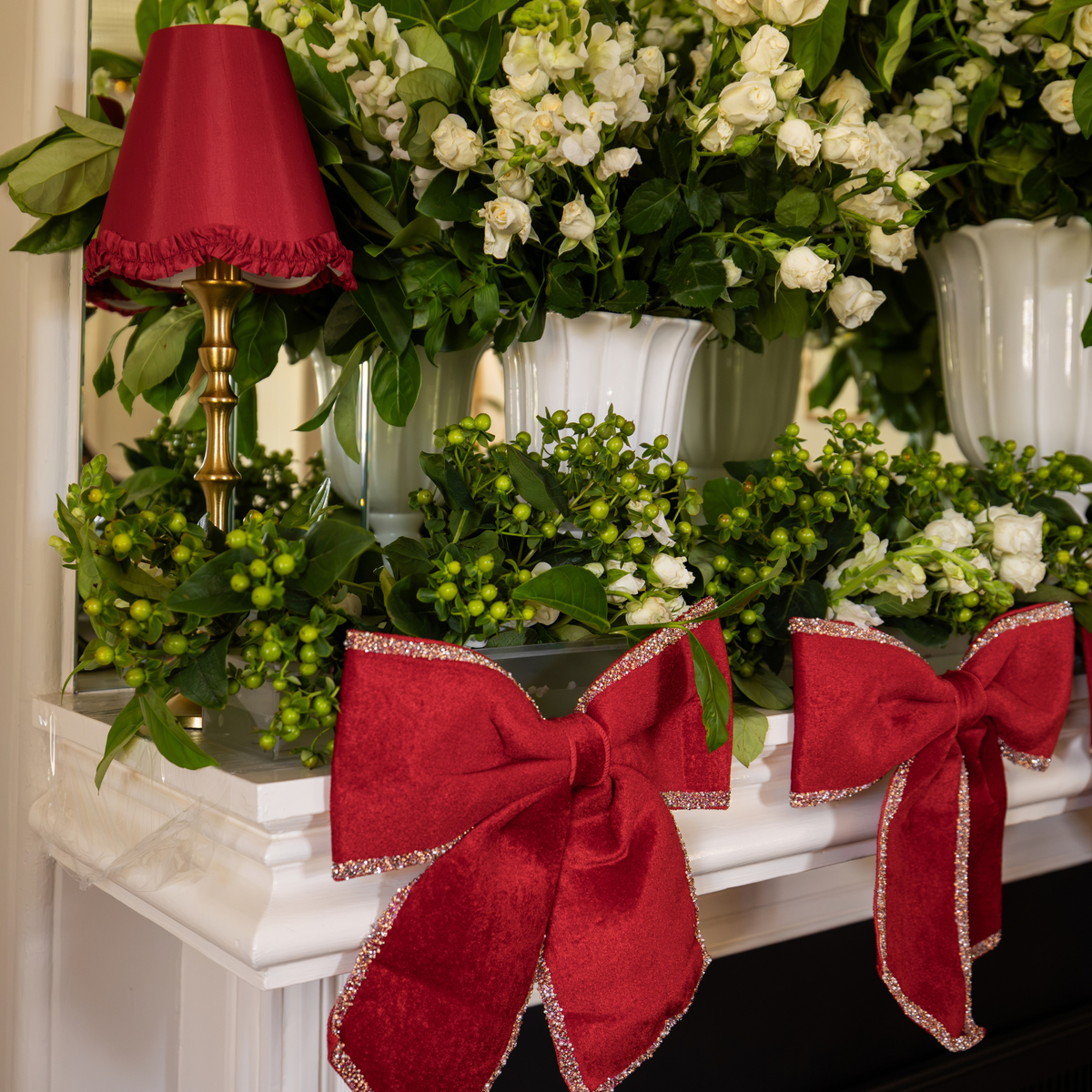 Pomegranate Christmas table styled with red velvet glitter trim bows and red ruffle lamp shade