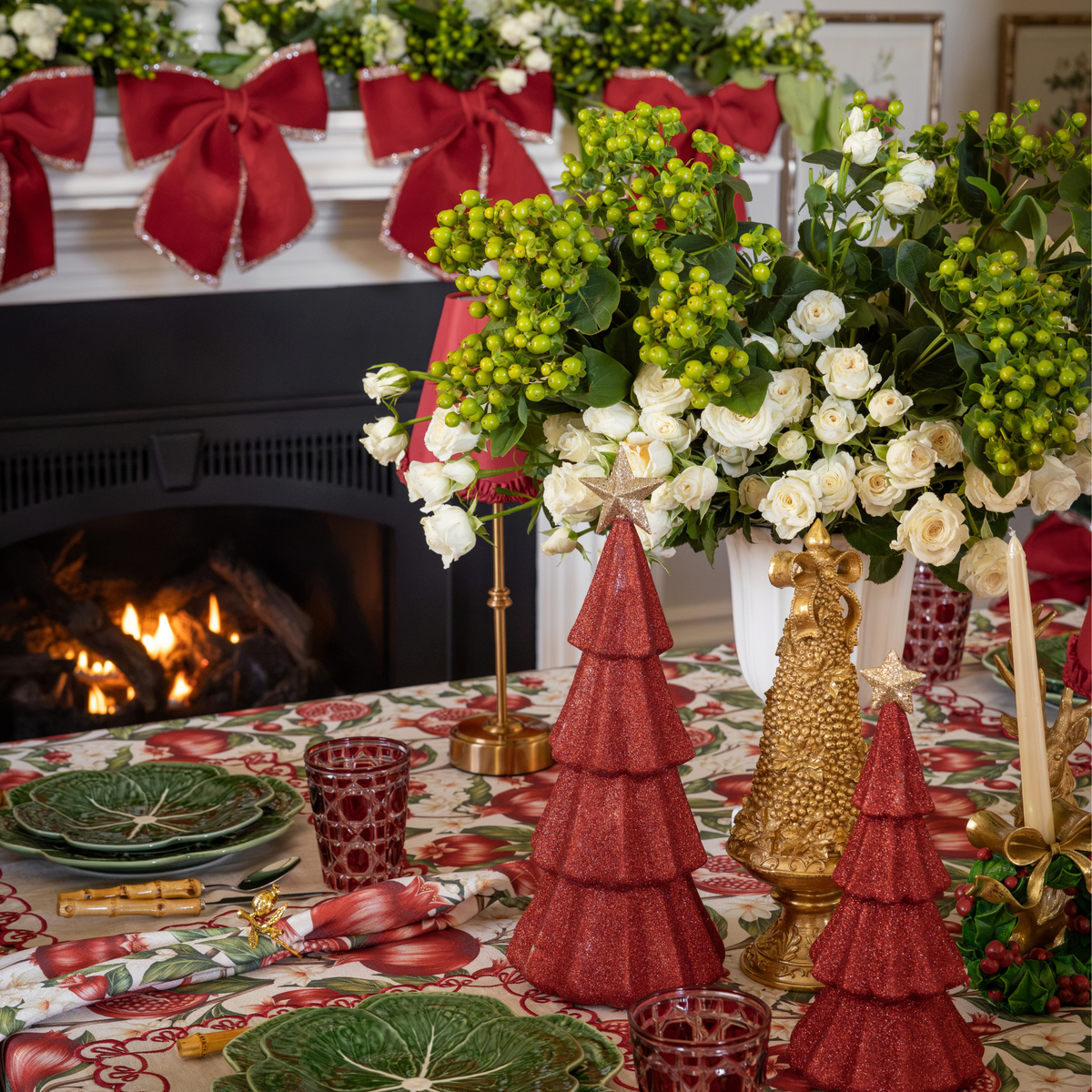 Pomegranate Christmas table styled with red glitter Christmas trees and gold Christmas tree