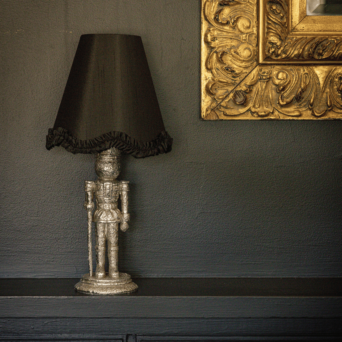 Spruce and Black Bow Christmas table styled with silver nutcracker lamp and black ruffle lamp shade