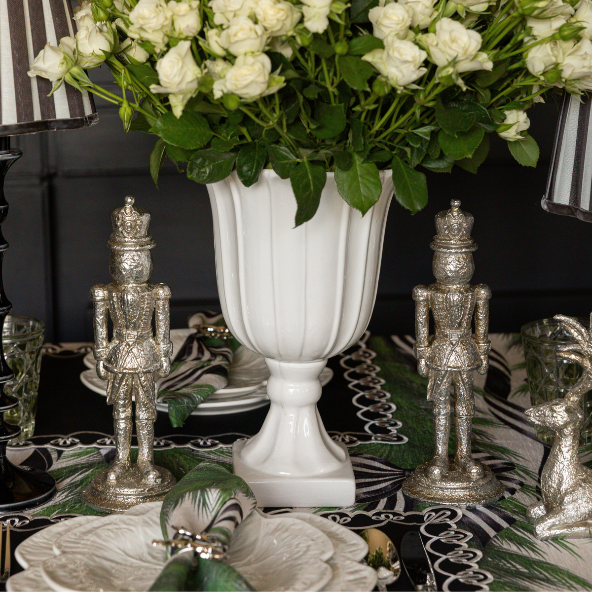Spruce and Black Bow Christmas table styled with silver nutcrackers and silver deer candle holders
