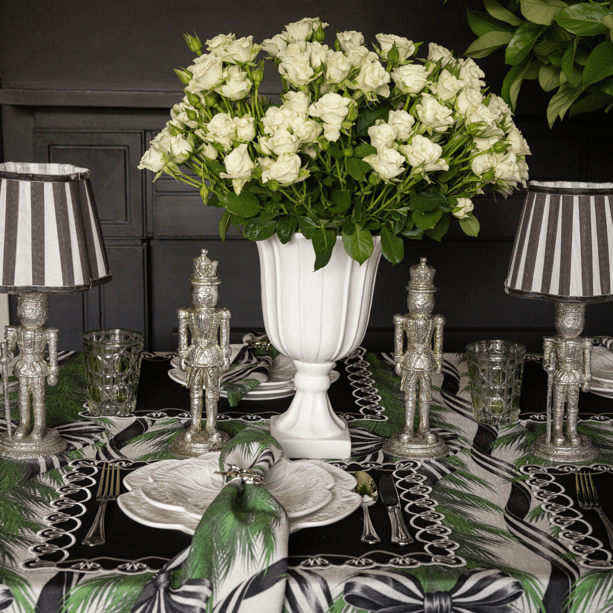 Spruce and Black Bow Christmas table styled with silver nutcracker lamp, black stripe lamp shade and silver nutcrackers