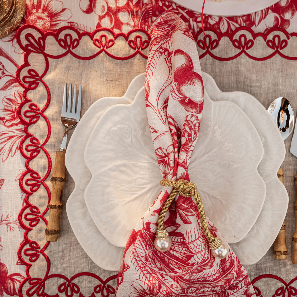Red Toile Christmas table styled with Red Toile napkins, white cabbage plates and pearl napkin rings
