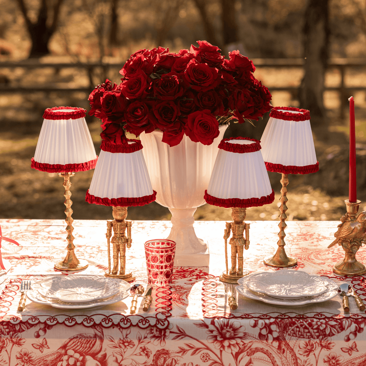 Red Toile Christmas table styled with Audrey snow white and red shade, gold nutcracker lamp and gold hammered lamp base