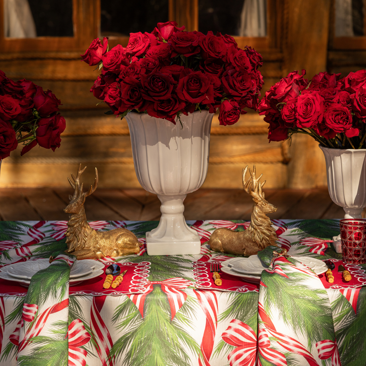 Spruce and Red Bow Christmas table styled with gold resting reindeer, Spruce and Red Bow table cloth and Spruce and Red Bow napkins