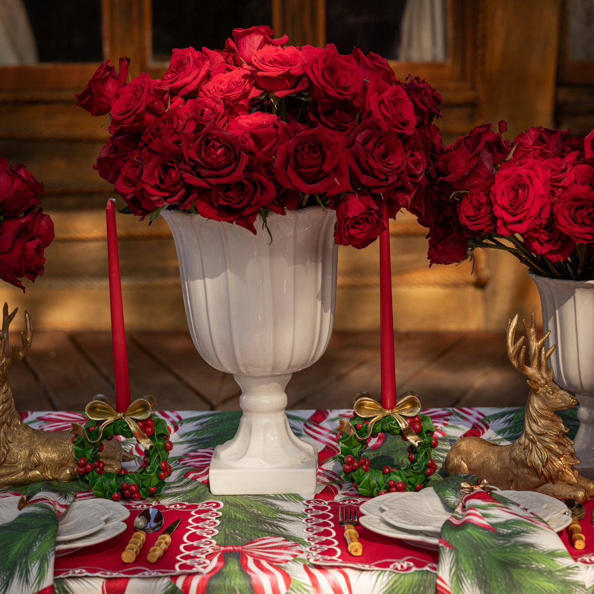 Spruce and Red Bow Christmas table styled with holly wreath candle holders and gold resting reindeer