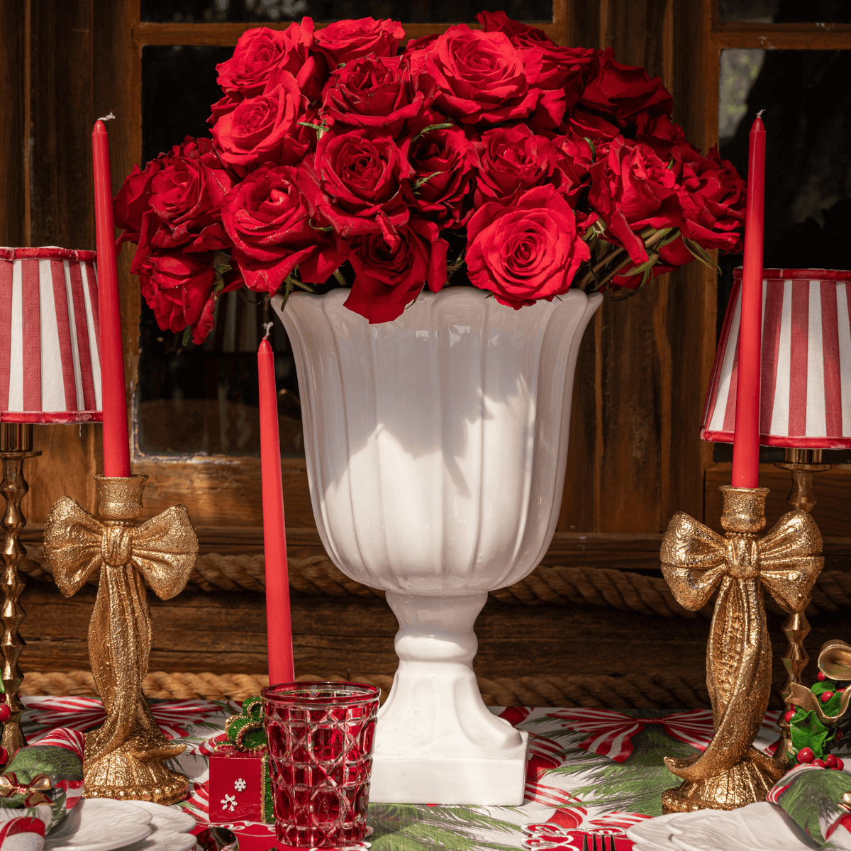 Spruce and Red Bow Christmas table styled with gold bow candle holders, red stripe lamp shade and gold hammered lamp base