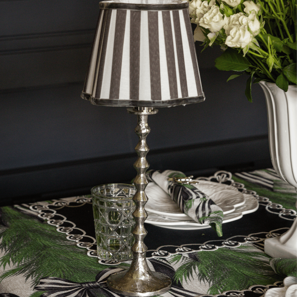 Spruce and Black Bow Christmas table styled with silver hammered lamp base and black stripe lamp shade