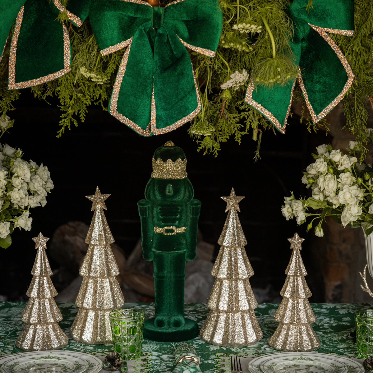 Green Toile Christmas table styled with dark green velvet nutcracker and champagne glitter Christmas trees