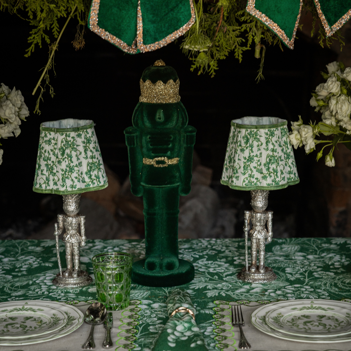 Green Toile Christmas table styled with dark green velvet nutcracker and silver nutcracker lamp