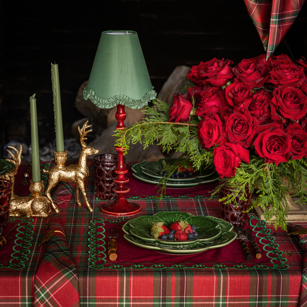 Red Tartan Christmas table styled with olive ruffle lamp shade, Rouge lamp base and gold deer candle holders