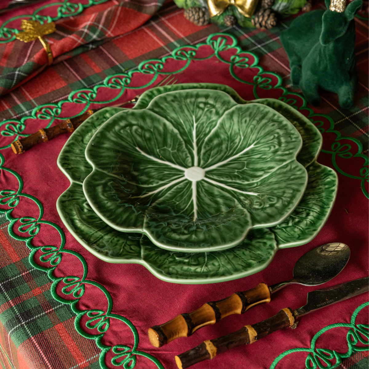 Red Tartan Christmas table styled with green cabbage plates, red placemats with green embroidery and gold leaf napkin rings