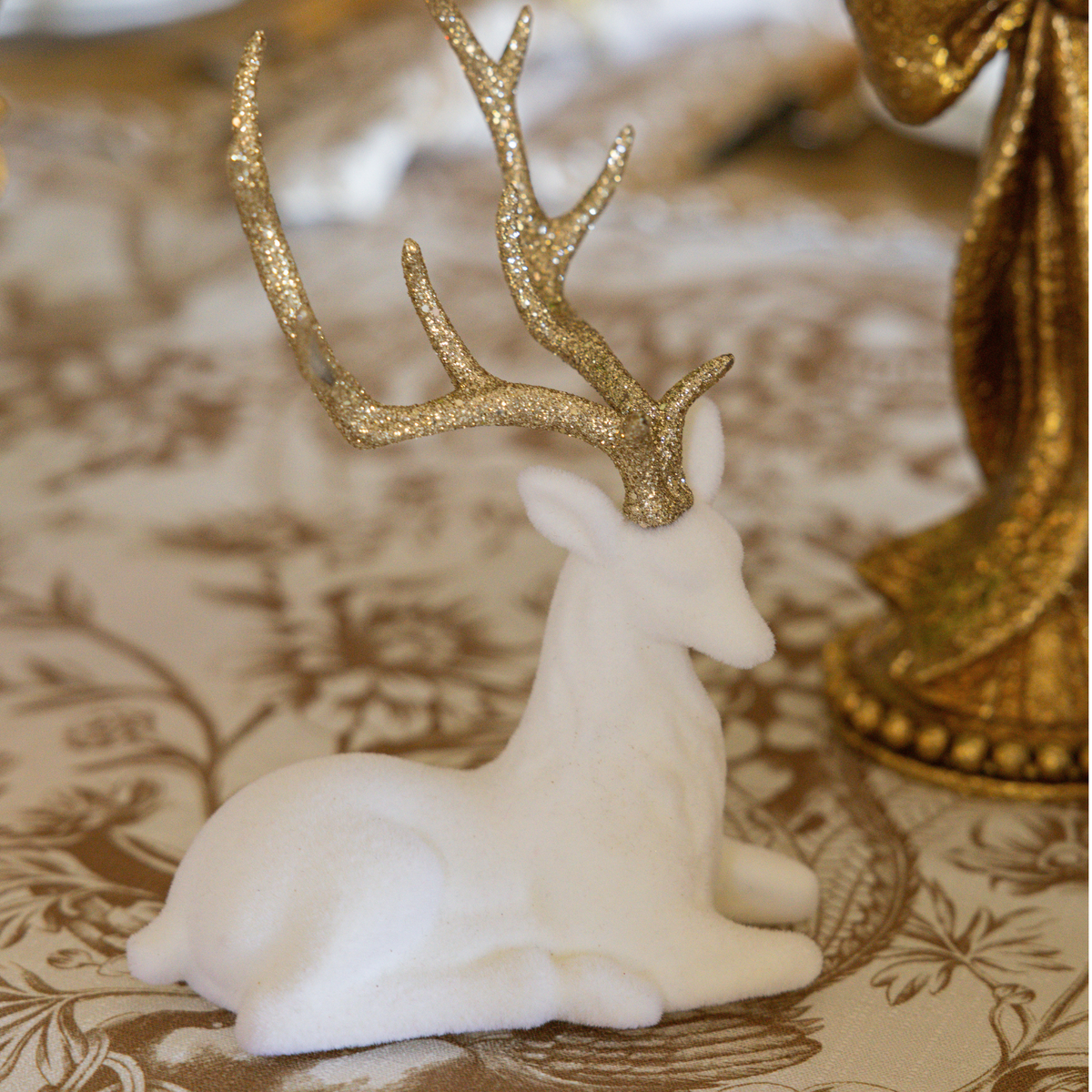 Gold Toile Christmas table styled with cream velvet reindeer
