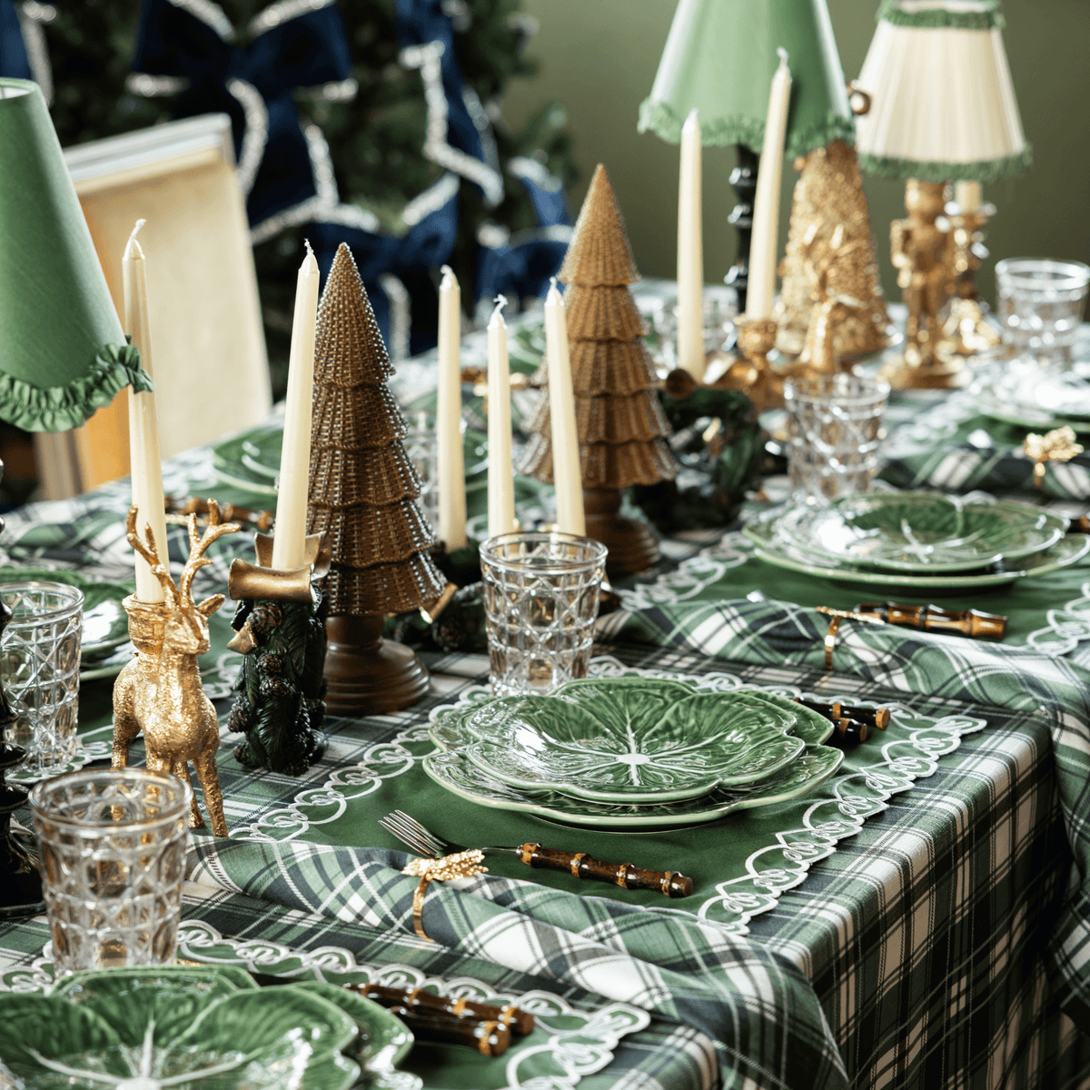 Green and Black Plaid Christmas table styled with dark brown rattan Christmas trees and gold deer candle holders