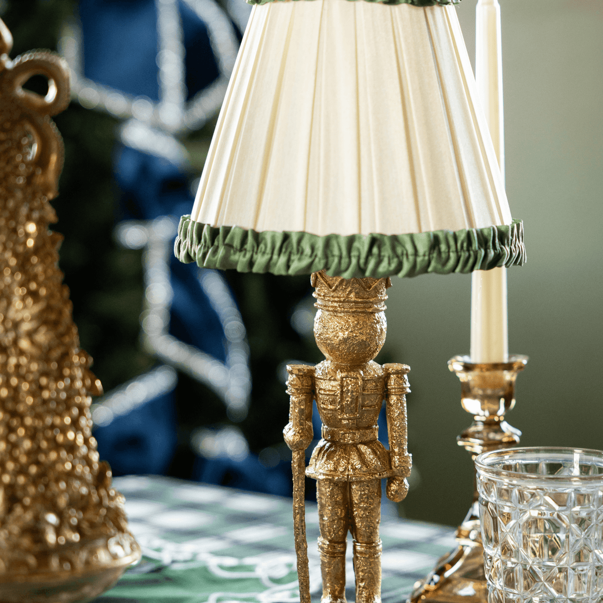 Green and Black Plaid Christmas table styled with gold nutcracker lamp and Audrey cream and hunter green shade