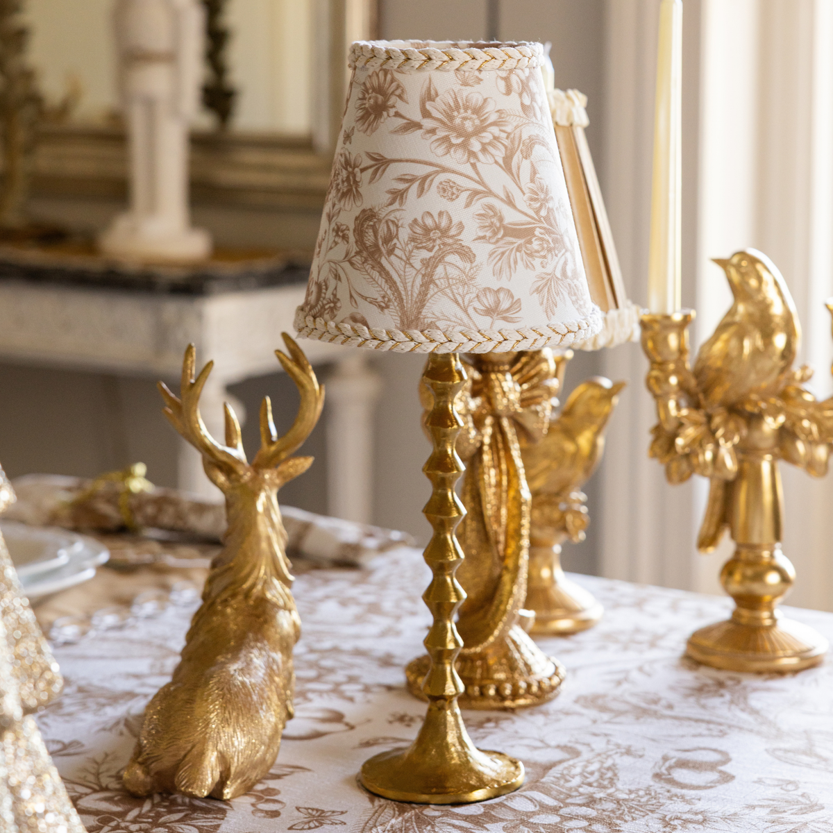 Gold Toile Christmas table styled with gold resting reindeer, Gold Toile lamp shade and gold hammered lamp base
