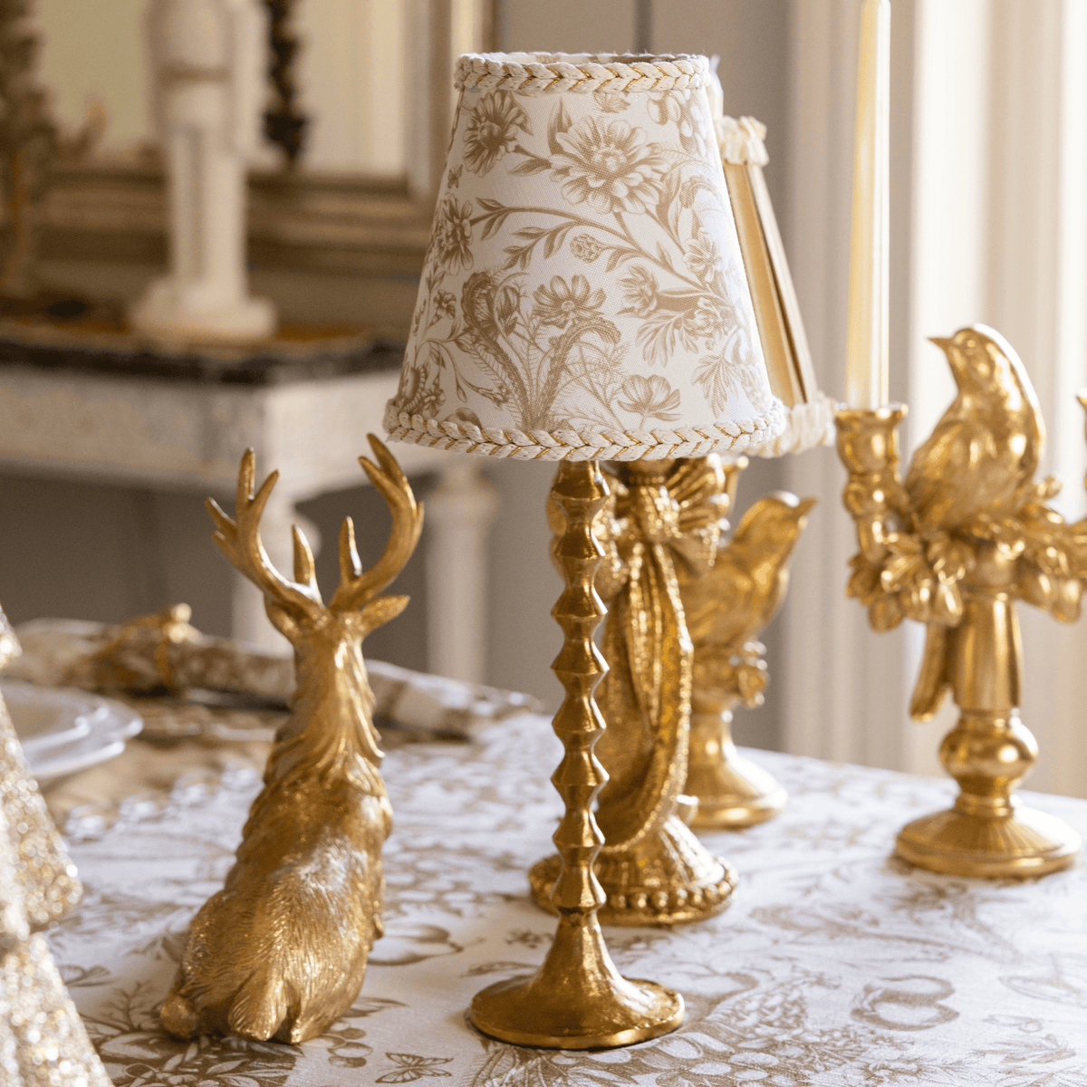 Gold Toile Christmas table styled with gold resting reindeer, Gold Toile lamp shade and gold hammered lamp base