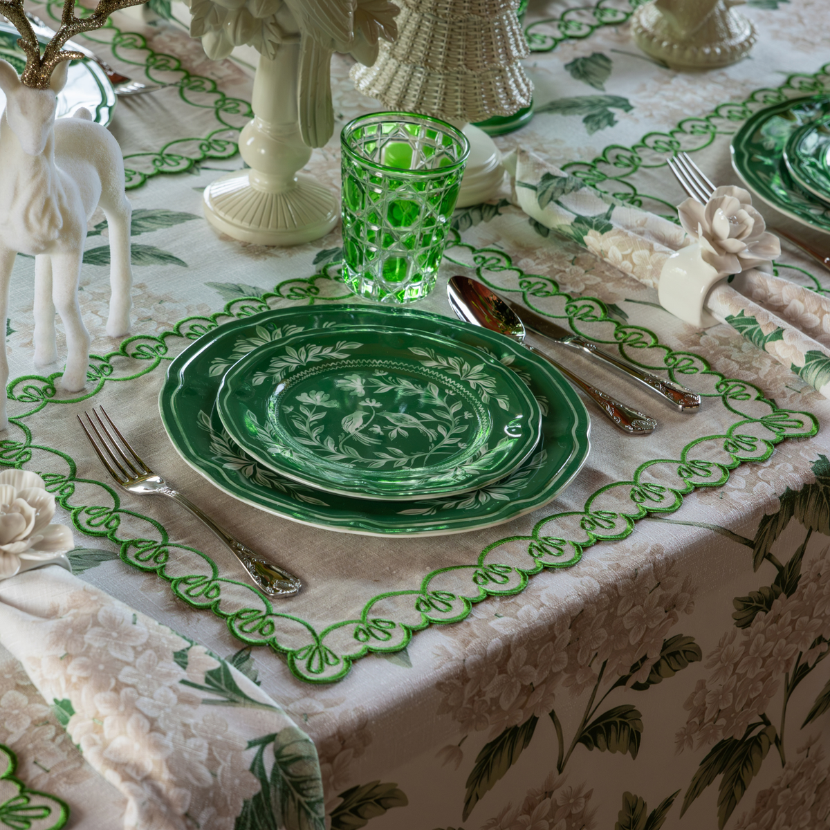 Cream Hydrangea Christmas table styled with green and white Chinoiserie plates, natural linen placemats with green embroidery and Fleur napkin rings