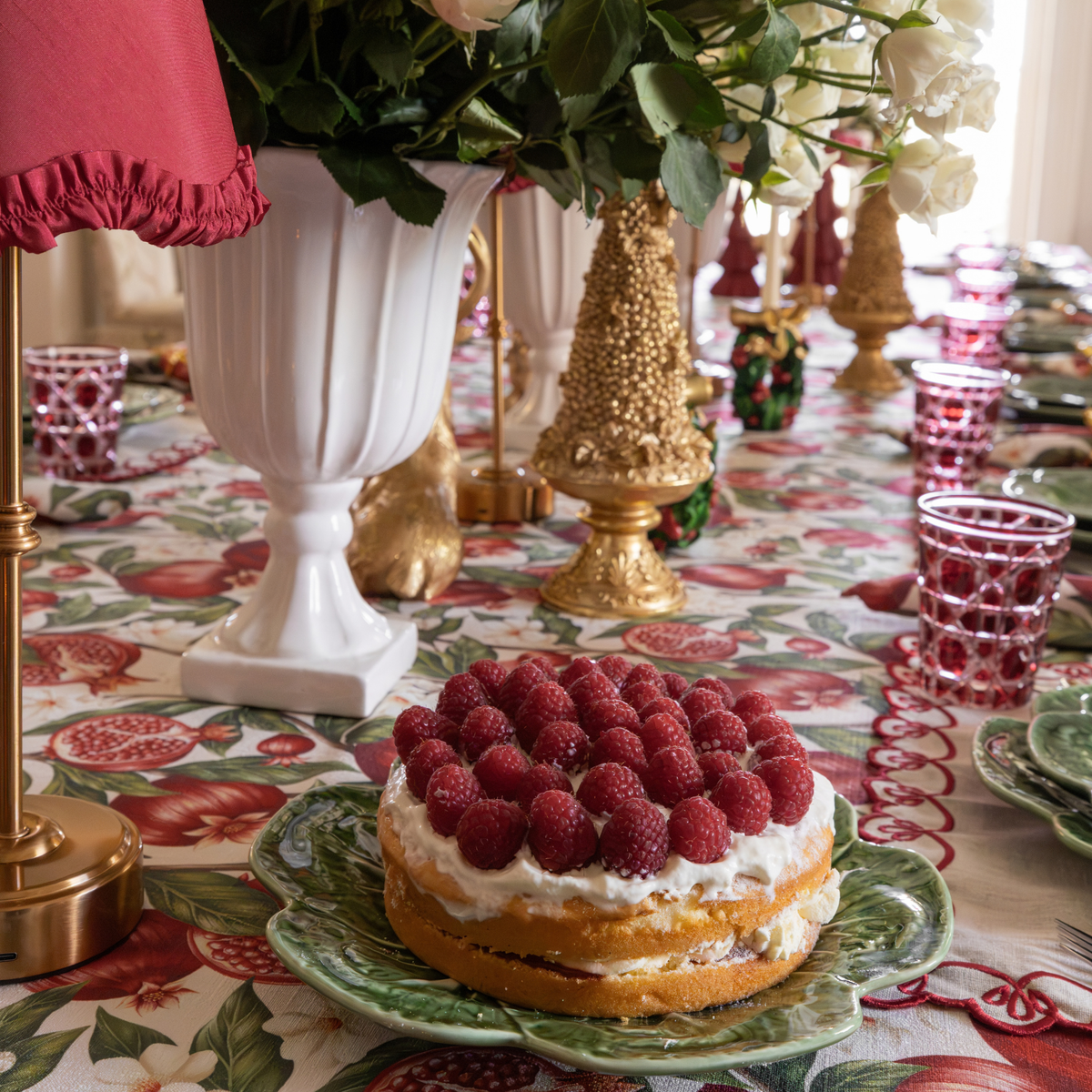Pomegranate Christmas table styled with red ruffle lamp shade and gold Christmas tree