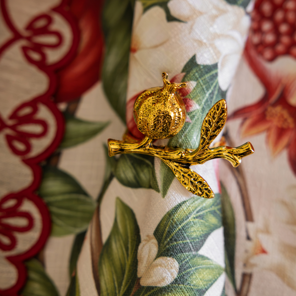 Pomegranate Christmas table styled with pomegranate napkin rings, Pomegranate napkins and natural linen placemats with red embroidery