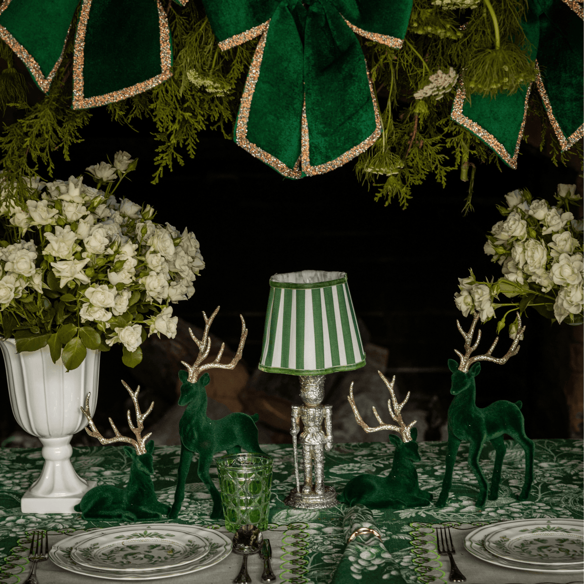 Green Toile Christmas table styled with silver nutcracker lamp, green stripe lamp shade and dark green velvet reindeer