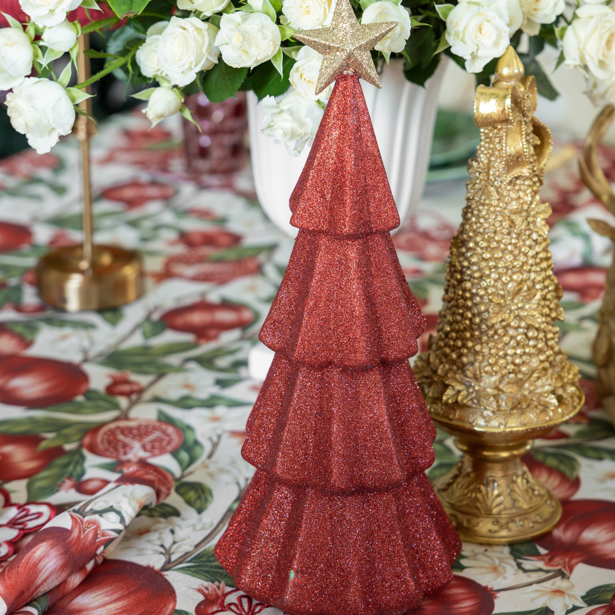 Pomegranate Christmas table styled with red glitter Christmas trees and gold Christmas tree