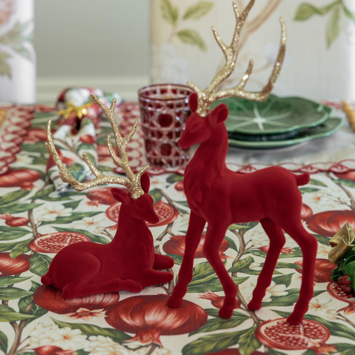 Pomegranate Christmas table styled with burgundy velvet reindeer