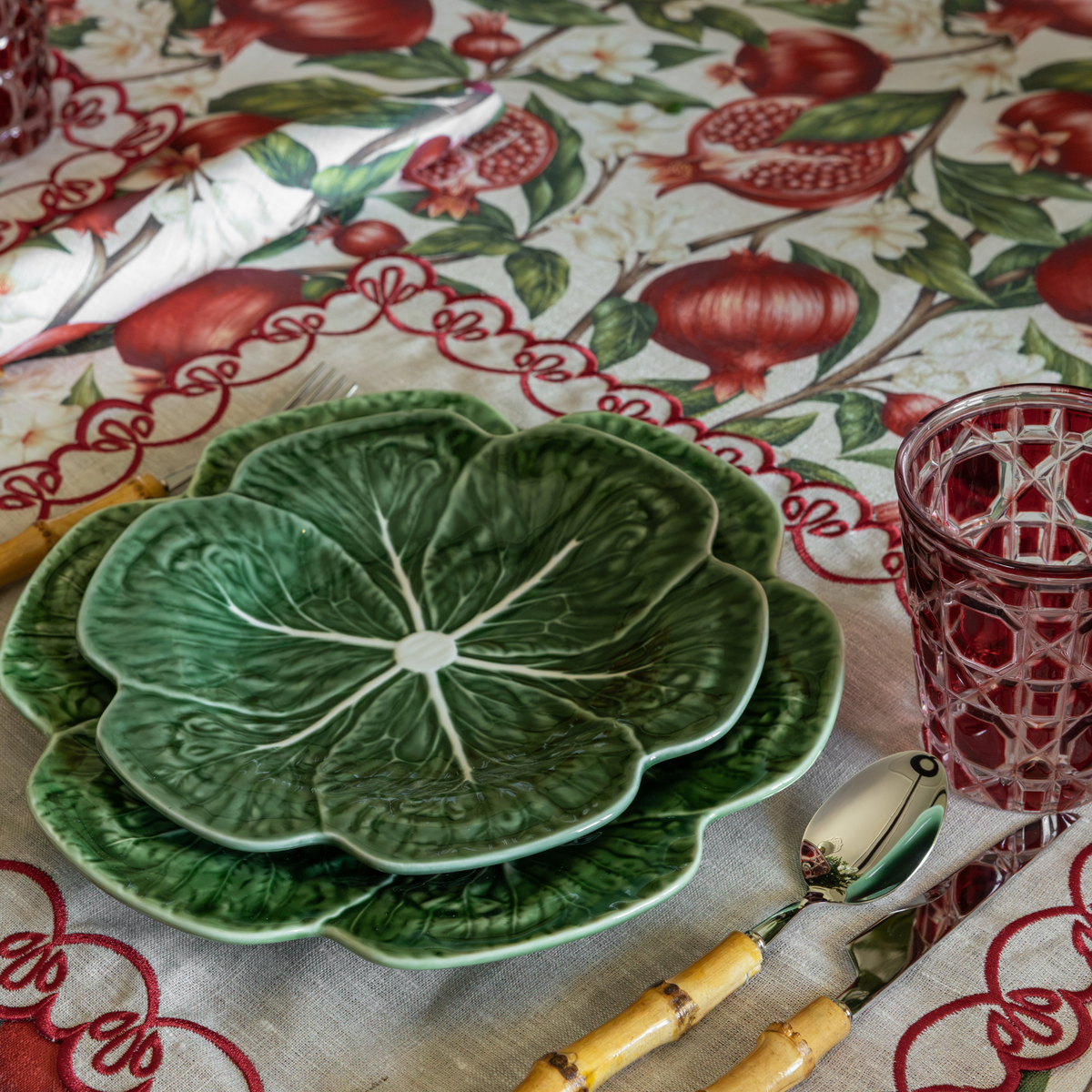 Pomegranate Christmas table styled with green cabbage plates and natural linen placemats with red embroidery