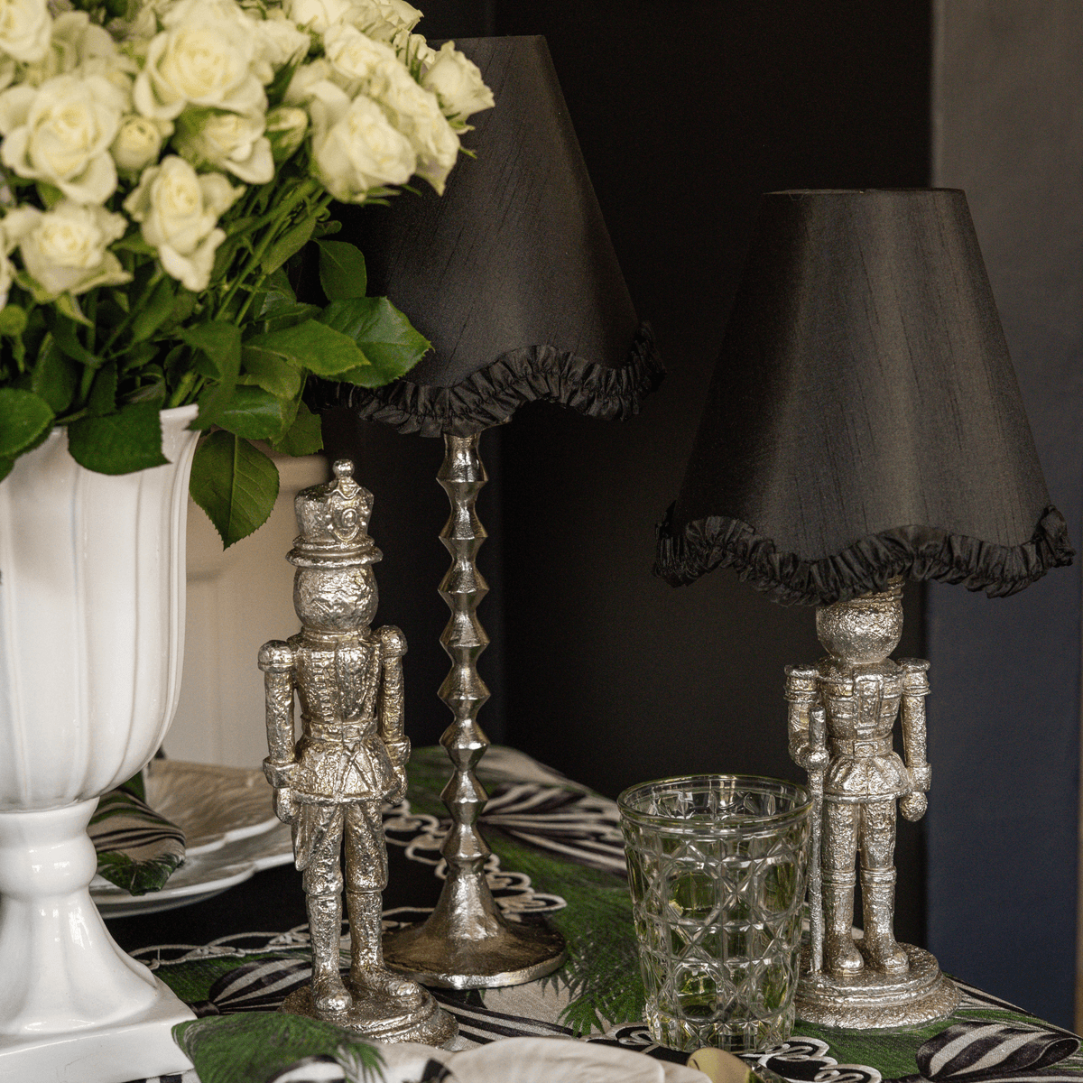 Spruce and Black Bow Christmas table styled with silver nutcracker lamp, black ruffle lamp shade and silver hammered lamp base