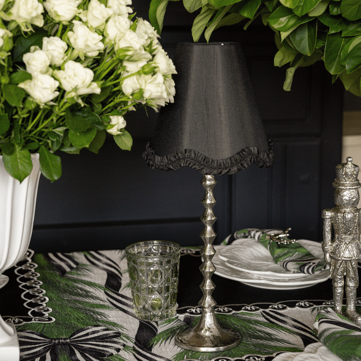 Spruce and Black Bow Christmas table styled with silver hammered lamp base, black ruffle lamp shade and silver nutcrackers