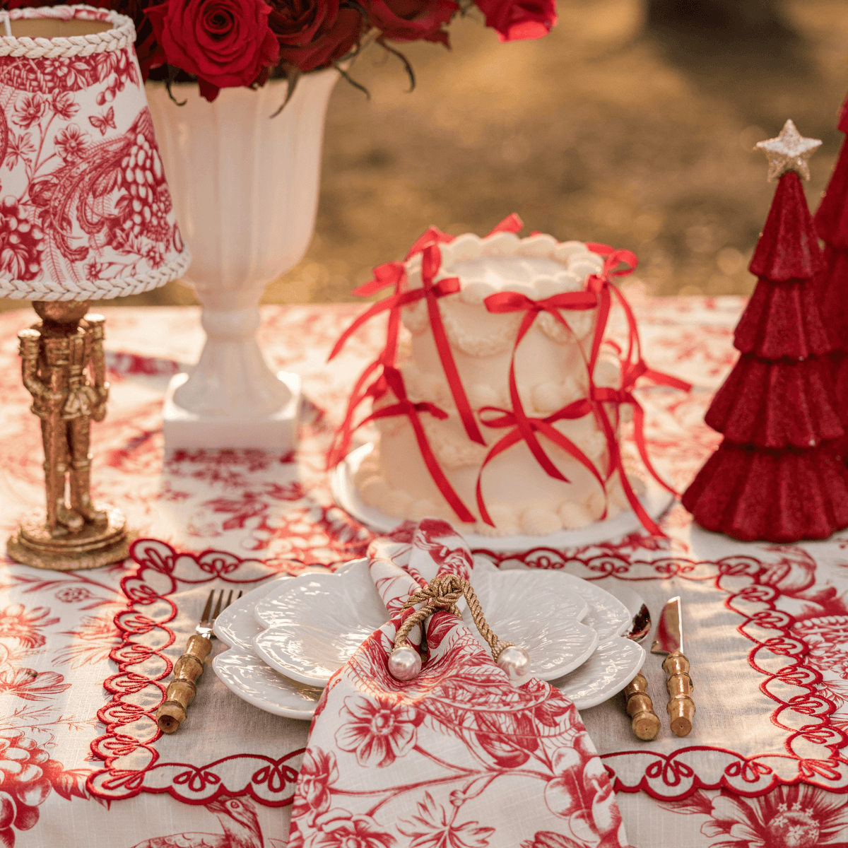 Red Toile Christmas table styled with Red Toile lamp shade, gold nutcracker lamp and Red Toile table cloth