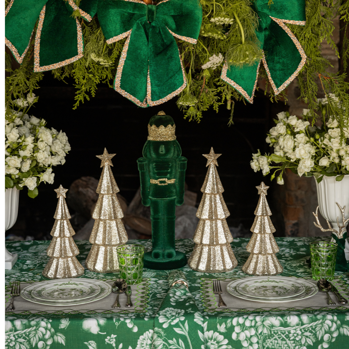 Green Toile Christmas table styled with dark green velvet nutcracker and champagne glitter Christmas trees