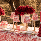 Red Toile Christmas table styled with Red Toile lamp shade, gold nutcracker lamp and gold hammered lamp base