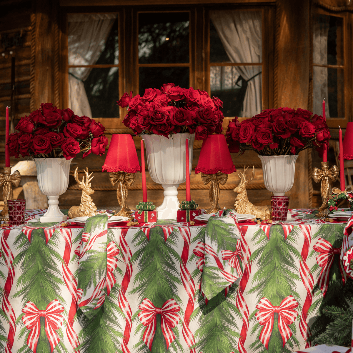 Spruce and Red Bow Christmas table styled with Spruce and Red Bow table cloth, Spruce and Red Bow napkins and gold bow lamp