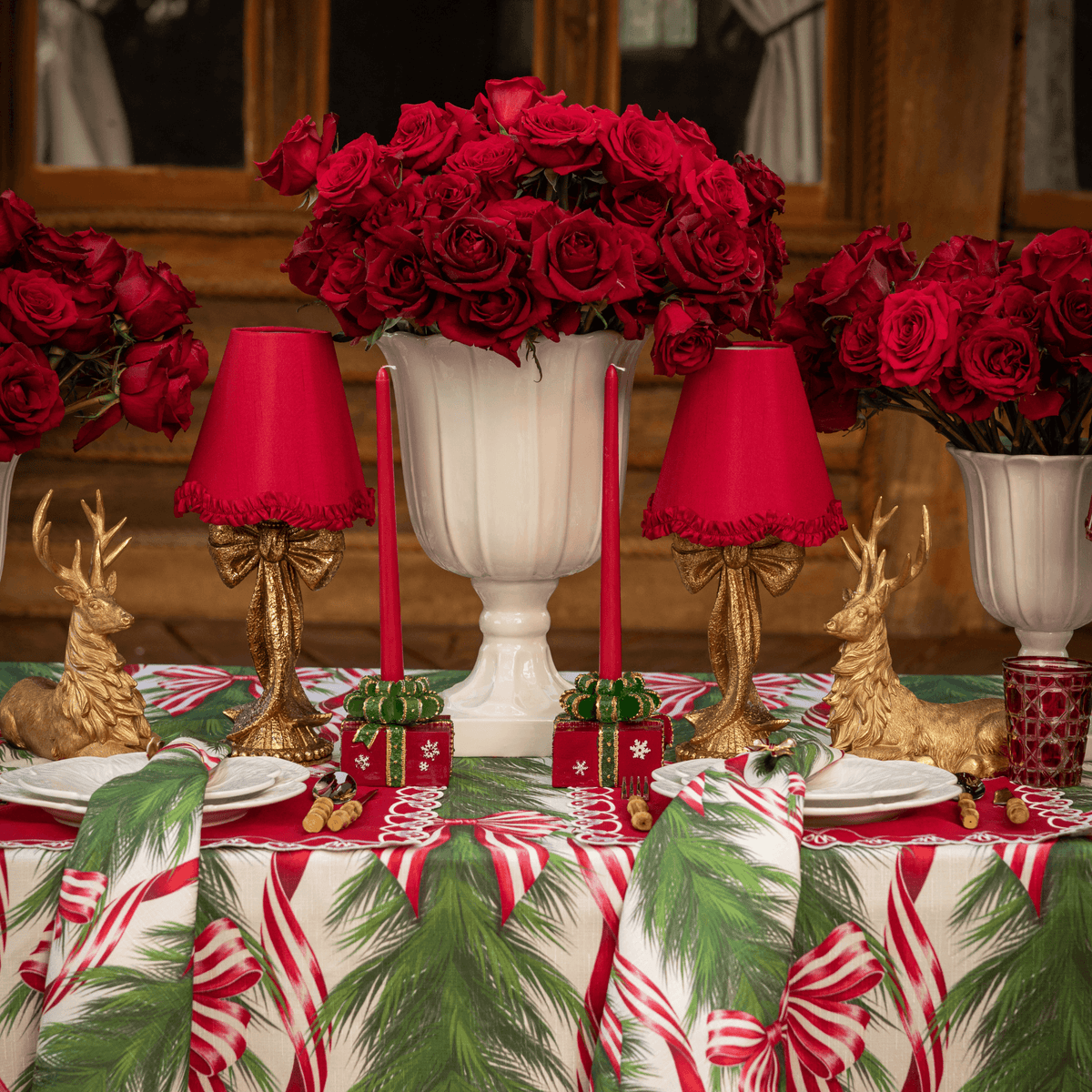 Spruce and Red Bow Christmas table styled with gold bow lamp, red ruffle lamp shade and gold resting reindeer