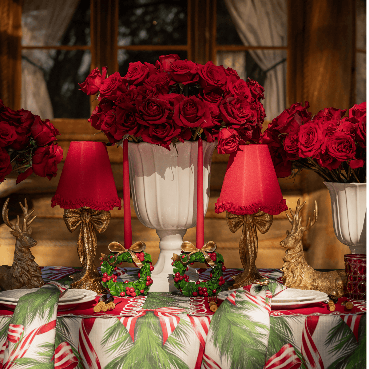 Spruce and Red Bow Christmas table styled with gold bow lamp, red ruffle lamp shade and gold resting reindeer