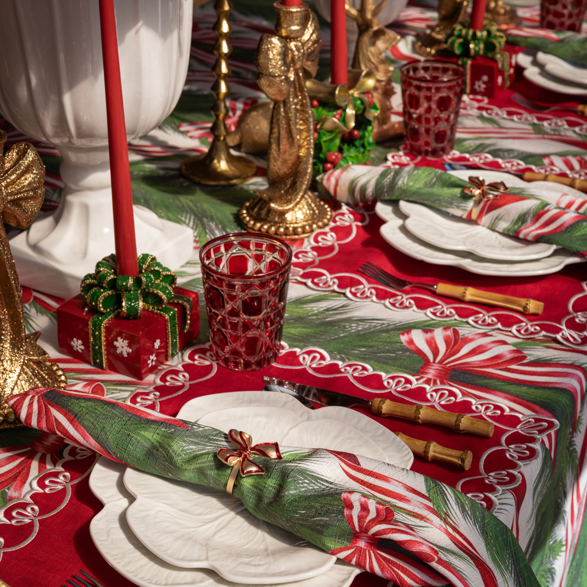 Spruce and Red Bow Christmas table styled with red Christmas present candle holders