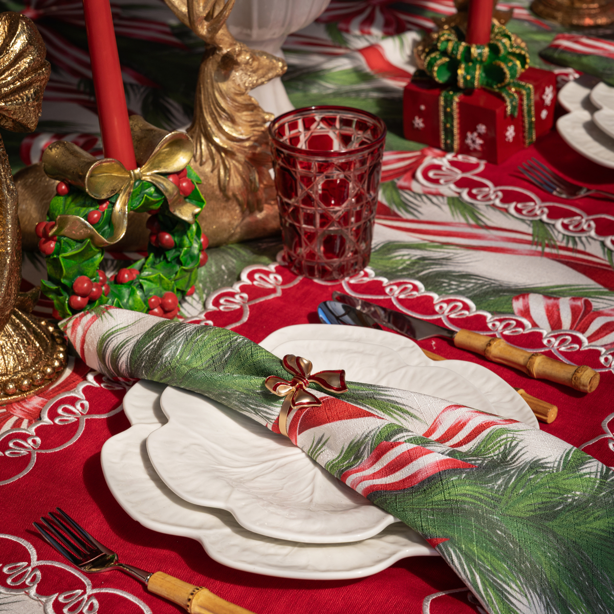 Spruce and Red Bow Christmas table styled with holly wreath candle holders