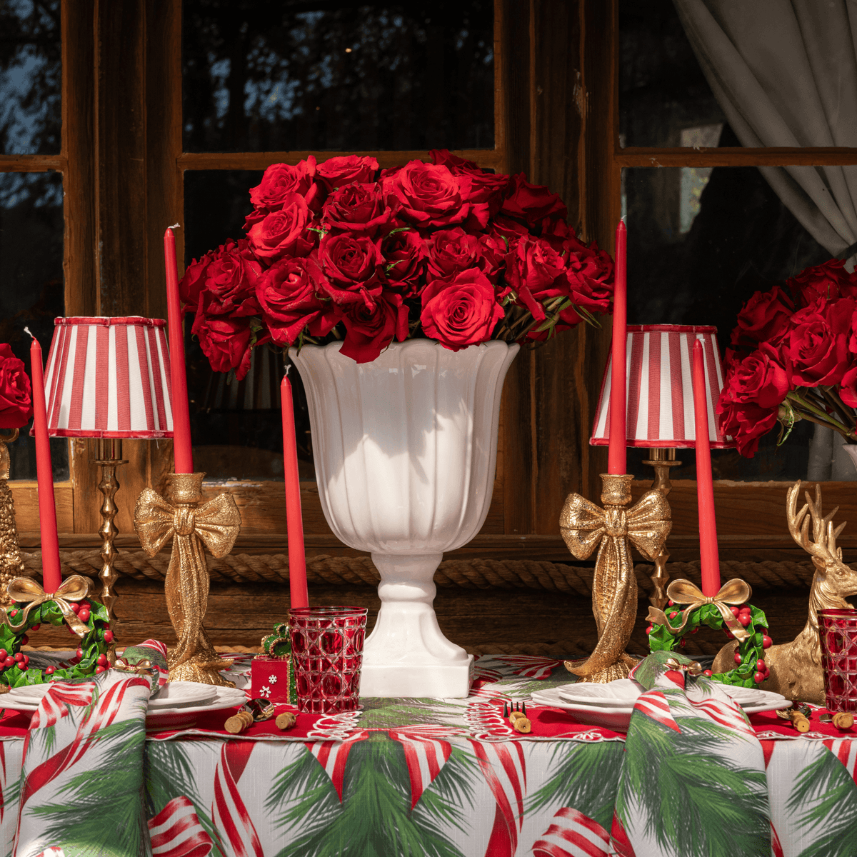 Spruce and Red Bow Christmas table styled with red stripe lamp shade, gold hammered lamp base and gold bow candle holders