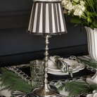 Spruce and Black Bow Christmas table styled with silver hammered lamp base and black stripe lamp shade