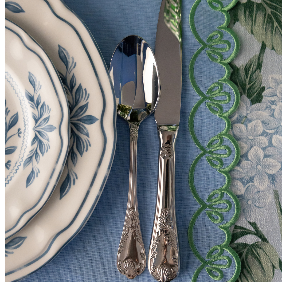 Blue Hydrangea Christmas table styled with white and blue Chinoiserie plates and pale blue placemats with green embroidery