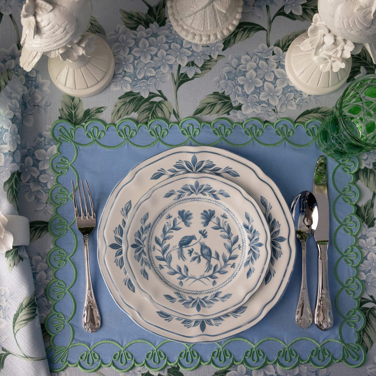 Blue Hydrangea Christmas table styled with white and blue Chinoiserie plates, pale blue placemats with green embroidery and Fleur napkin rings