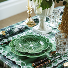 Green and Black Plaid Christmas table styled with green cabbage plates and green placemats with ivory embroidery