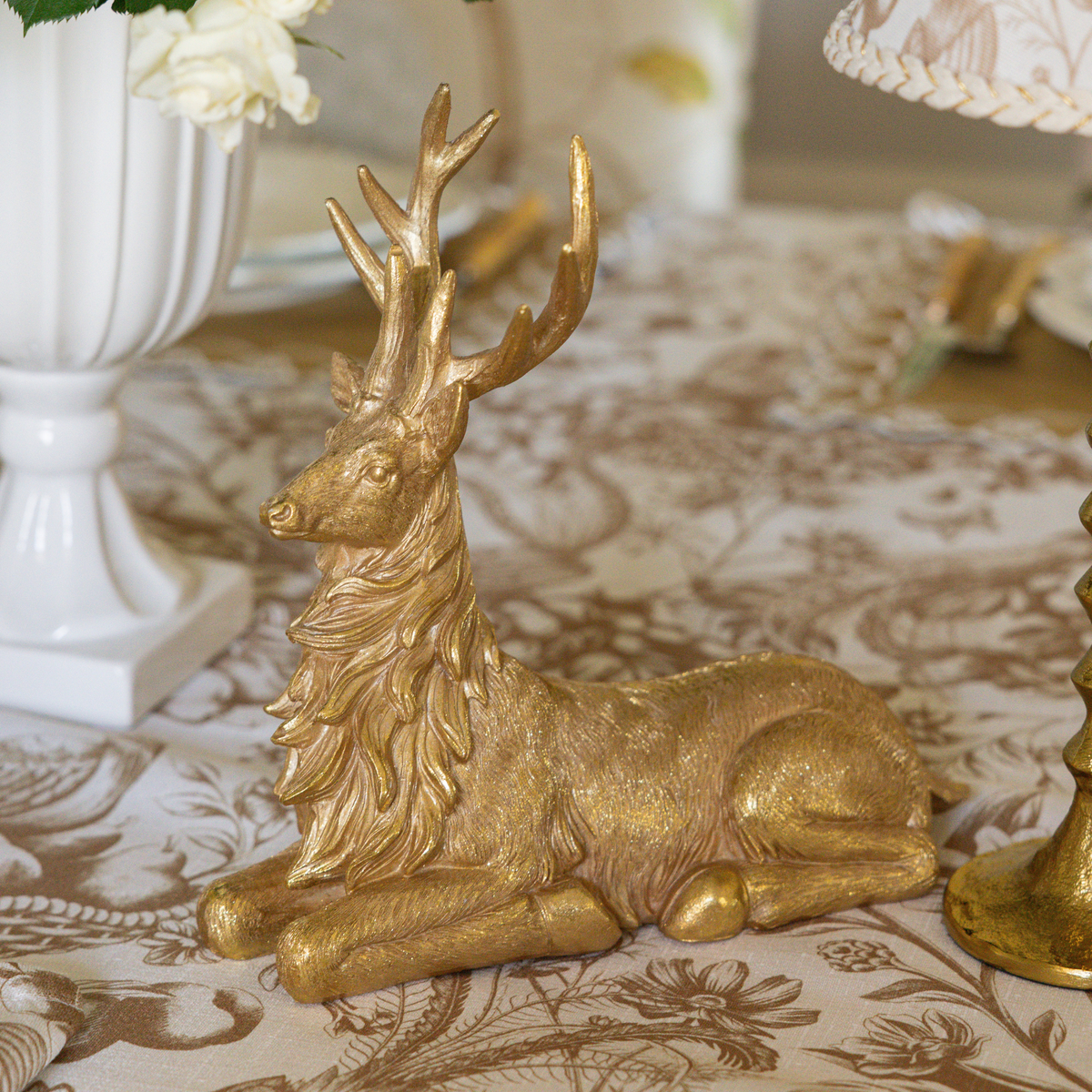 Gold Toile Christmas table styled with gold resting reindeer