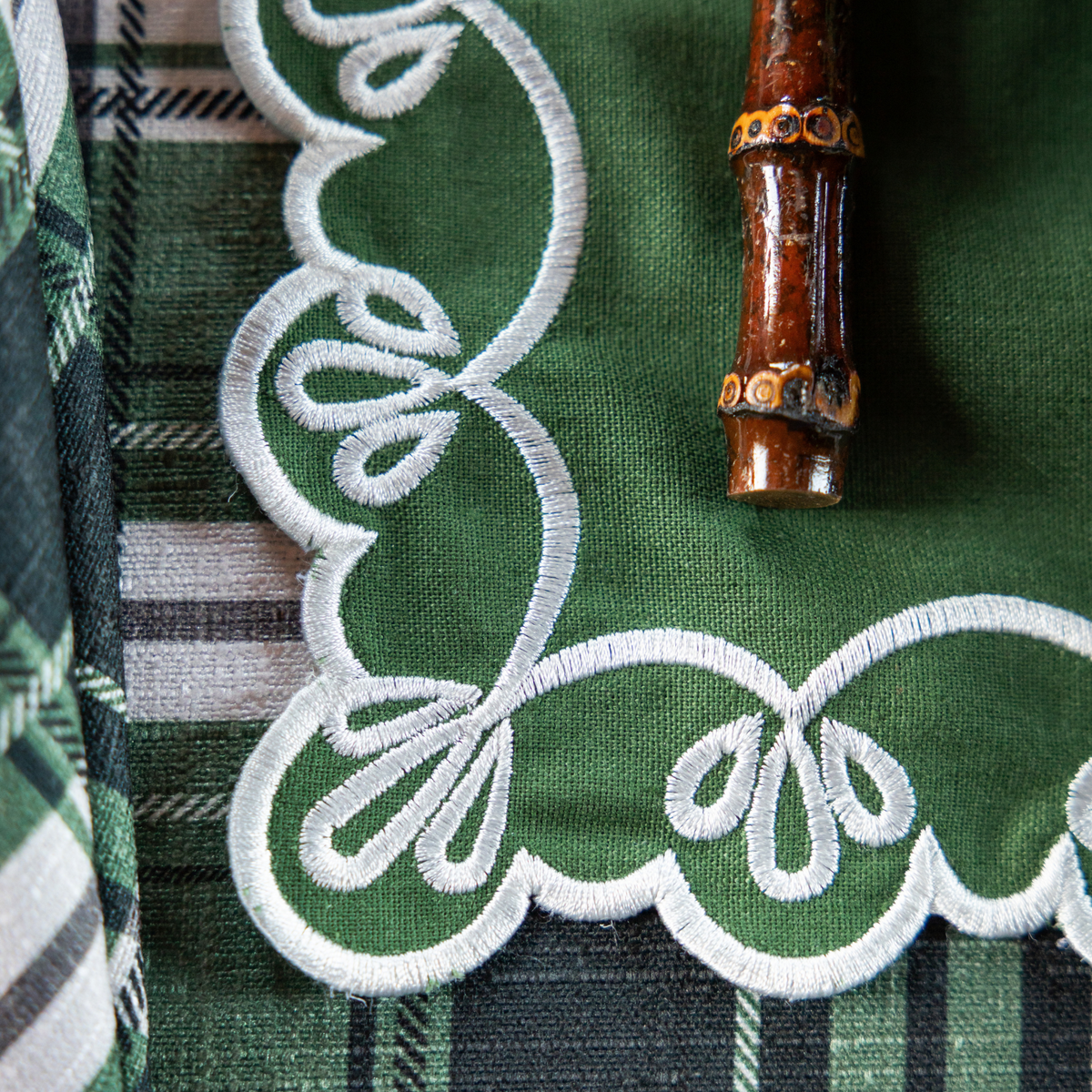 Green and Black Plaid Christmas table styled with green placemats with ivory embroidery