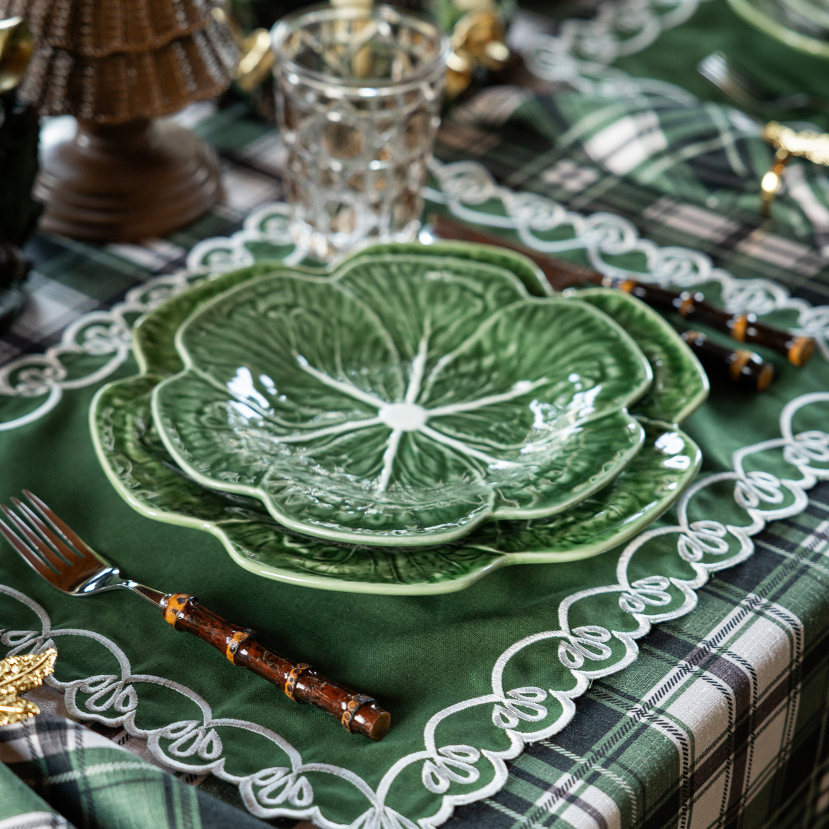 Green and Black Plaid Christmas table styled with green cabbage plates and green placemats with ivory embroidery