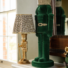Green and Black Plaid Christmas table styled with gold nutcracker lamp and dark green velvet nutcracker