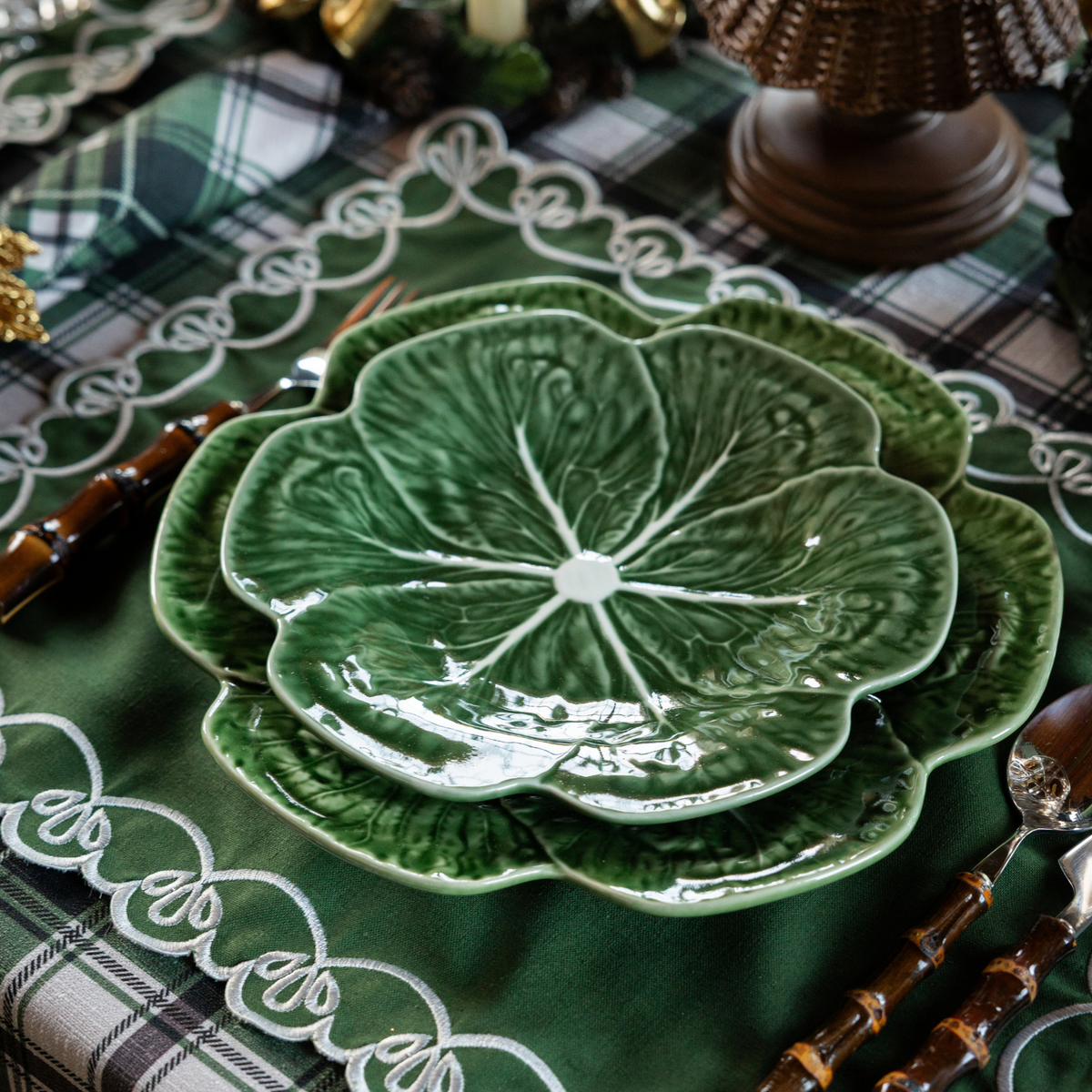 Green and Black Plaid Christmas table styled with green cabbage plates and green placemats with ivory embroidery
