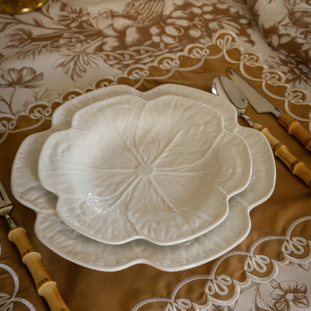 Gold Toile Christmas table styled with white cabbage plates and gold placemats with ivory embroidery