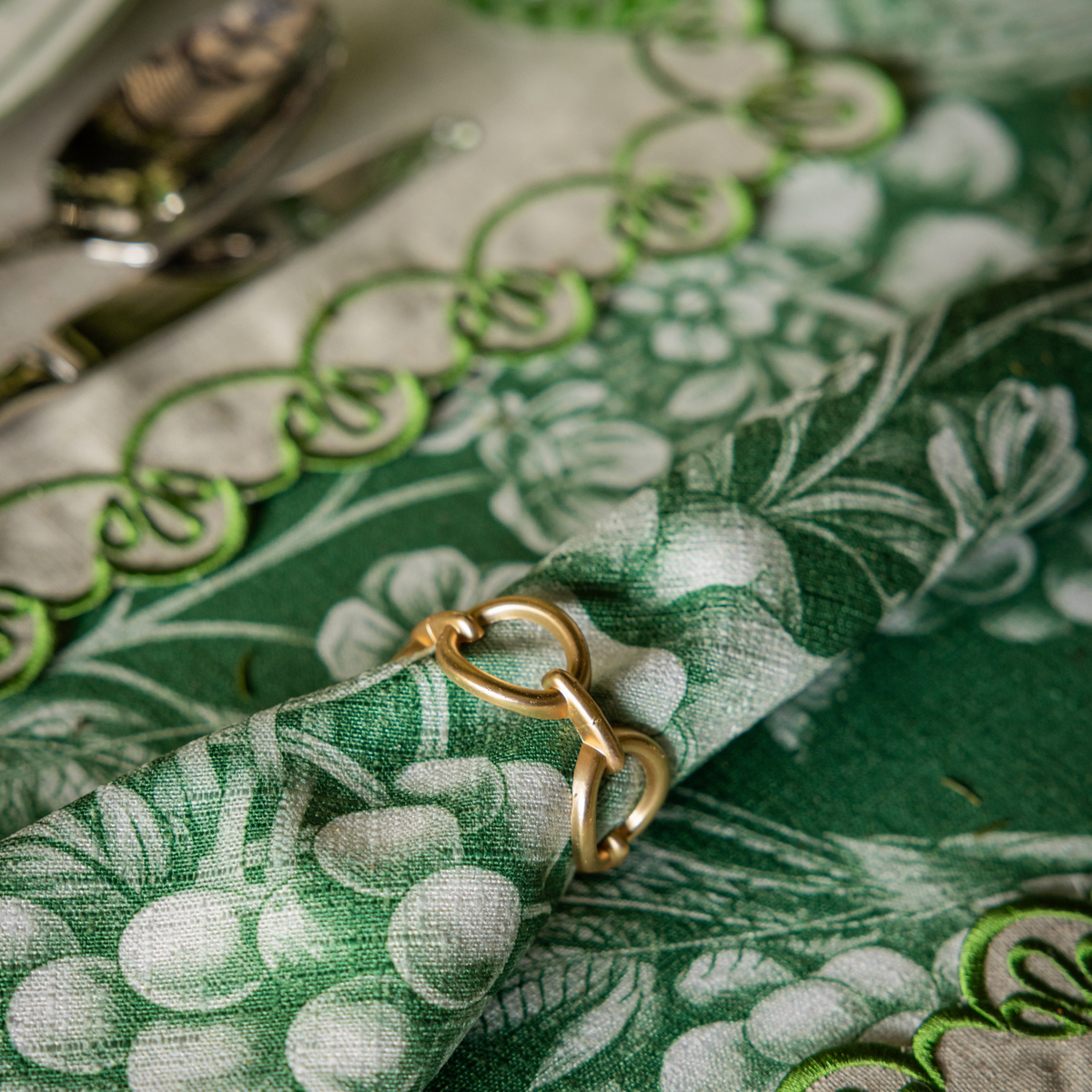 Green Toile Christmas table styled with Chaine napkin rings, Green Toile napkins and natural linen placemats with green embroidery